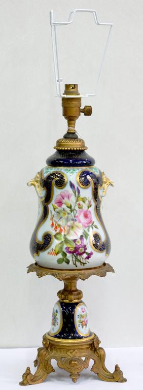 A GILTMETAL MOUNTED CONTINENTAL PORCELAIN OIL LAMP, PAINTED WITH FLOWERS IN COBALT AND GILT BORDERS,