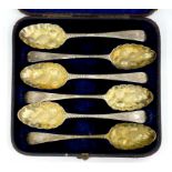 SIX GEORGE III ENGLISH AND IRISH SILVER TABLE SPOONS, LATER CHASED AND GILT AS A SET OF BERRY