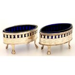 A PAIR OF GEORGE III PIERCED AND ENGRAVED NAVETTE SHAPED SALT CELLARS ON CLAW AND BALL FEET, BLUE