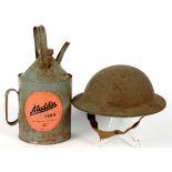 A WORLD WAR II TIN HELMET AND AN ALADDIN PARAFFIN CAN