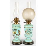 TWO SIMILAR VICTORIAN PAINTED TURQUOISE GLASS OIL LAMPS WITH BRASS FOUNT ON BLACK AND GILT