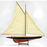 A WELL MADE VARNISHED WOOD POND YACHT WITH SAILS AND RIGGING, THE HULL PAINTED BLACK WITH WHITE