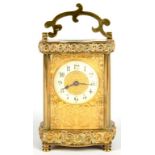 A FRENCH BRASS CARRIAGE TIMEPIECE, WITH FINELY PIERCED AND ENGRAVED GILT BRASS TRACERIED MASK AND