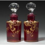 A PAIR OF GILT RUBY GLASS COLOGNE BOTTLES AND FACETED GILT GLASS STOPPERS, POSSIBLY BACCARAT,