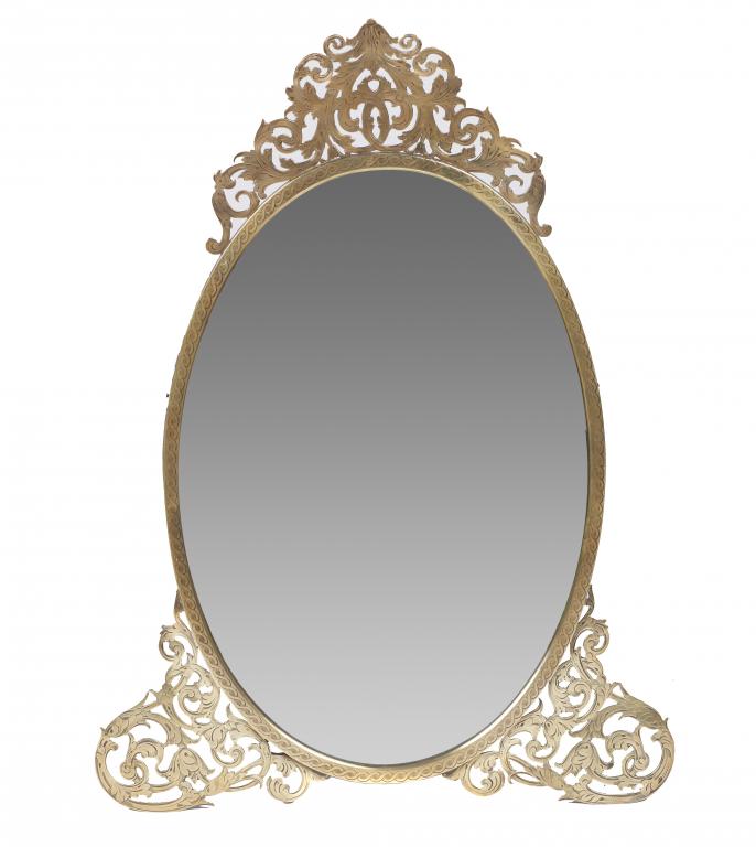 A VICTORIAN OVAL BRASS DRESSING MIRROR with engraved fretwork cresting and feet, pierced strut, 75cm