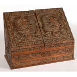 A CHINESE CARVED WOOD SLOPE-FRONT STATIONERY BOX, EACH DOOR CARVED WITH A DRAGON BORDERED BY BATS