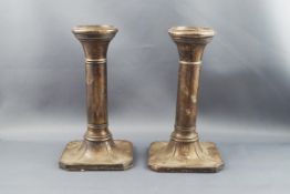 A pair of silver candlesticks, each round column on a canted-square base,