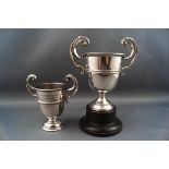 Two silver small campagna shaped trophy cups, each with two flying scroll handles,