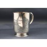 A Victorian silver christening mug with a scroll handle and engraved with two children in a meadow