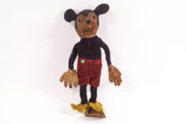 A 1930's Mickey Mouse toy with felt body and red shorts,