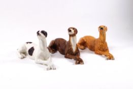 Three Beswick figures of recumbent greyhounds, black and white, brindle and fawn,
