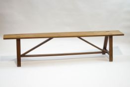 A Continental fruitwood bench with 'A' shape supports,