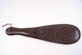 A Maori paddle, carved with two inter-linked scrolls,