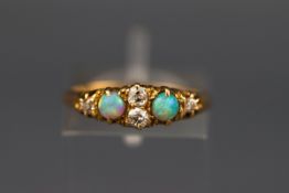 An early 20th century gold, opal and diamond ring, centered with two small old-cut diamonds,