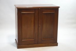 A Victorian mahogany cupboard with two panelled doors on plinth base,