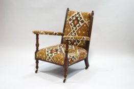 A Victorian oak and open armchair on turned front supports,