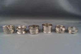 Six silver napkin rings, various designs, dates and makers, 113g gross.