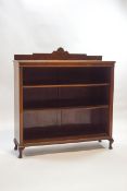 An early 20th century mahogany bookcase with raised back and two shelves on cabriole legs,