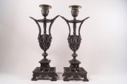 A pair of 19th century pierced pewter candlesticks in the Baroque style with brass drip trays,