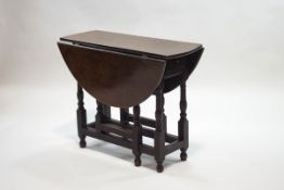 A 17th century style oak drop leaf gateleg table, on turned and block legs,