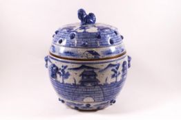 A 20th century Chinese earthenware bulbous pot and cover with underglaze blue decoration of pagodas