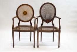 An Edwardian mahogany elbow chair with caned seat and back, inset with inlaid plaque,