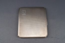 A silver engine turned oblong cigarette case with script initials 'SM',
