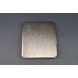 A silver engine turned oblong cigarette case with script initials 'SM',