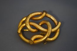 A Victorian gilt metal part foliate engraved knot brooch, 56mm wide.