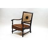 An early 20th century cane and leather armchair with copper studding,