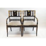 A pair of Regency style lacquered and gilded elbow chairs,