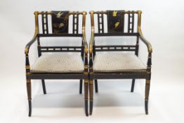 A pair of Regency style lacquered and gilded elbow chairs,