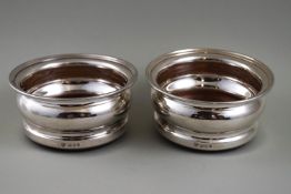 A pair of silver mounted coasters with turned wood bases, London 1964 by C J Vander, 9.