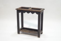 A Victorian carved oak stick stand, the central divider with brass handle,