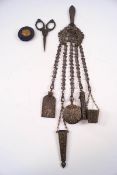 An early 20th century white metal chatelaine comprising: ivory aide memoire, scissors, pin cushion,