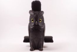 A carved wall pocket in the form of an owl, containing clothes brushes,