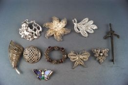 Eight silver and white metal brooches in various designs including a Celtic sword shaped brooch,