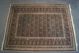 A 20th century Caucasian multi-coloured carpet with repeating stylised geometric motifs to the