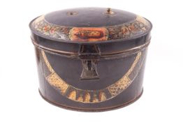 An early 19th century oval tole ware box, painted with shells and flowers on a black ground,