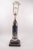 A Trench art table lamp, the chromed shell case upon a stepped marble base,