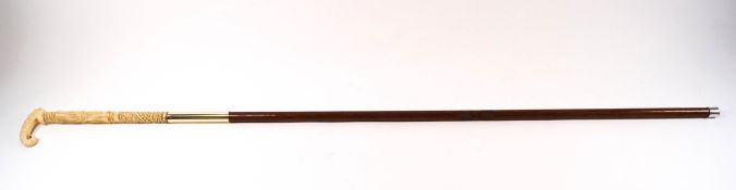 A slim ladies cane with early 20th century carved ivory handle