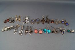 A collection of silver and white metal earrings in various designs, some gem set, various marks.