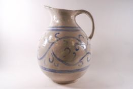 A large Continental bulbous pottery jug with blue painted swirl and band decoration,