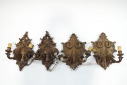 A set of four carved wall lights, each with carved and pierced cartouche,