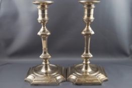 A pair of silver candlesticks with round capitals and nozzels, knopped stems on sunk centre,