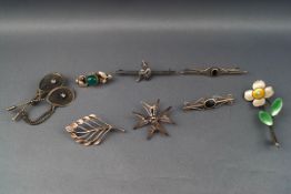 Eight various silver and white metal brooches including a polycrome enamelled flower,