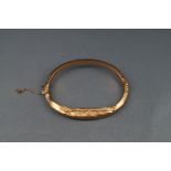 An early 20th centuy 9ct rose gold hollow knife-edge hinged bangle, (badly damaged),