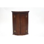 A 19th century oak and inlaid hanging corner cupboard with two shelves,