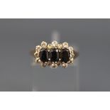 A 9ct gold, sapphire and cubic zirconia triple-cluster ring, the London hallmarks obscured, size R+,