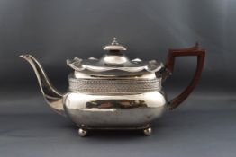 A George III silver oblong teapot with a shaped gadrooned border,